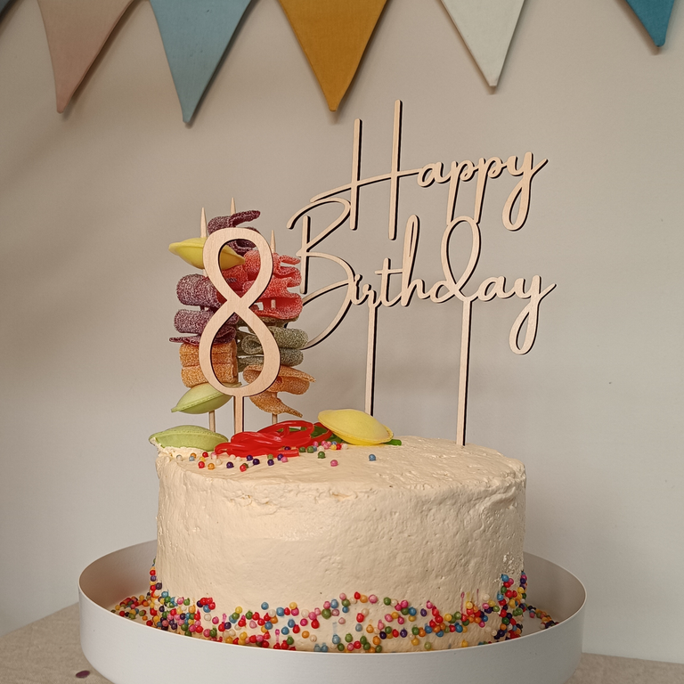 Caketopper mit dem Schriftzug „Happy Birthday“ und Zahl 8 aus Holz auf einer Geburtstagstorte.